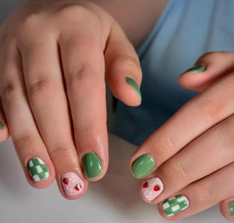 Sage green checkerboard nails with hand-painted cherries