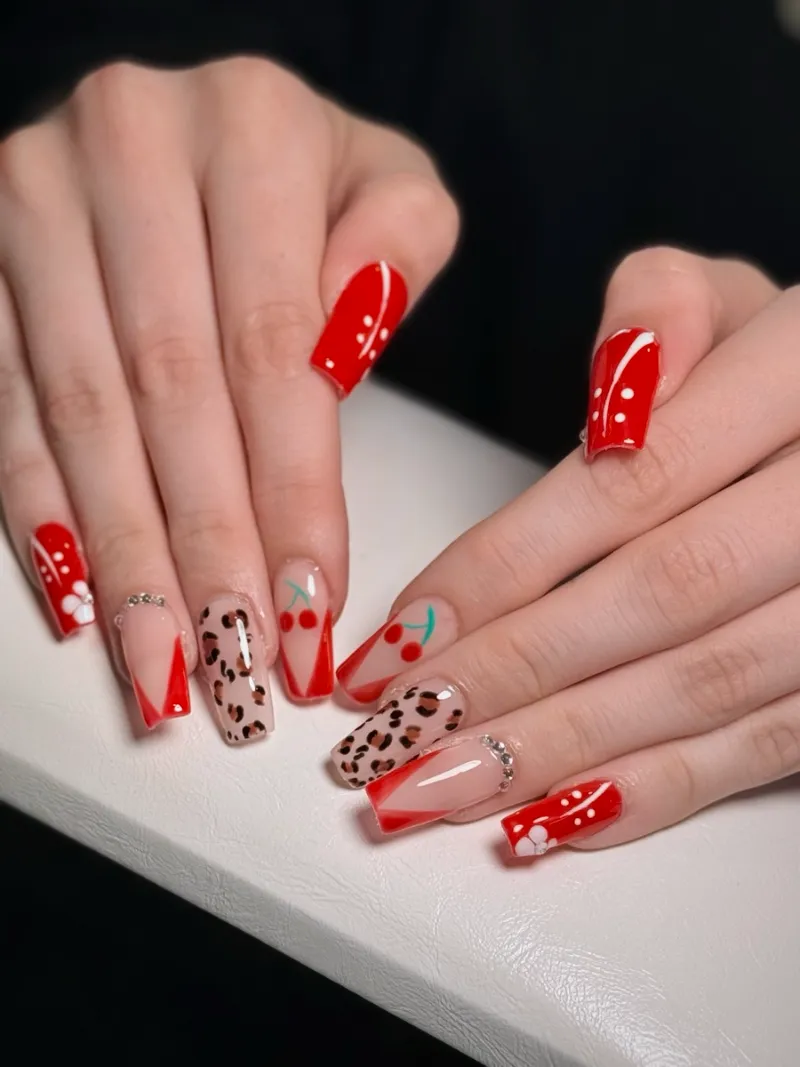 Red square gel nails with leopard print and hand-painted cherries, done by Nikole at Nail Oasis in St. George, Utah