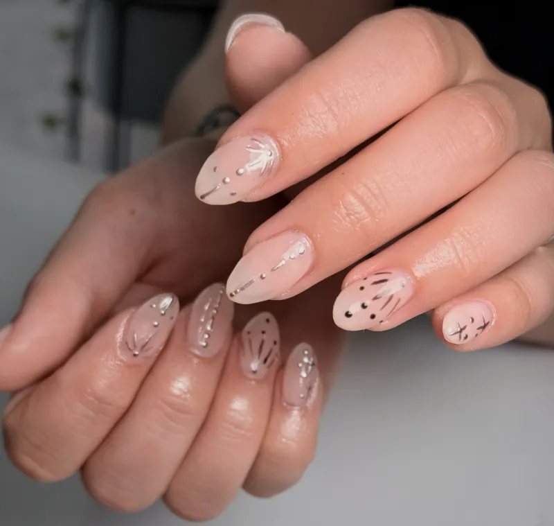 Nude almond nails with fine hand-painted line art by Nikole, founder of Nail Oasis